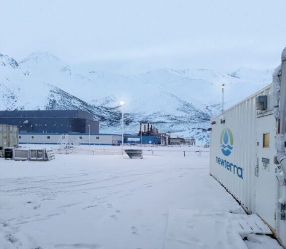 Newterra Clear3 installation in Yellowknife, Canada in winter with the MBR unit on the right near an industrial processing system in the mid-ground and center to left, snow covered mountains are in the background