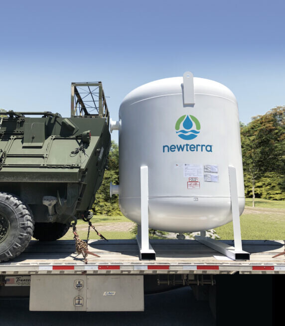 A Newterra Cansorb high pressure liquid phase active carbon adsorber on a trailer with a military vehicle