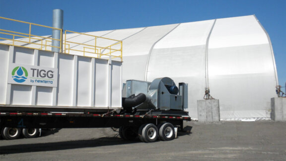 A portable Nixtox vapor adsorber is loaded on a trailer near a fabric building in an outdoor setting