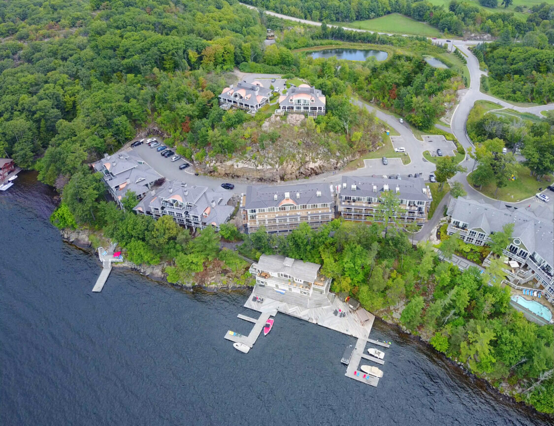 Aerial view of a waterfront residential development area with seven multiunit condominiums