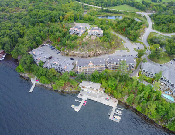 Aerial view of a waterfront residential development area with seven multiunit condominiums