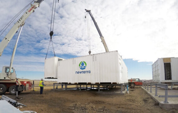 Water treatment professionals gather around a water treatment tank