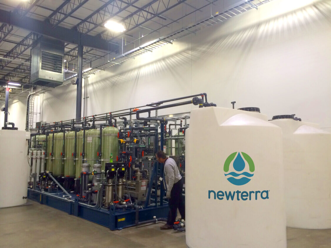 Newterra technician inspects reverse osmosis industrial water treatment equipment